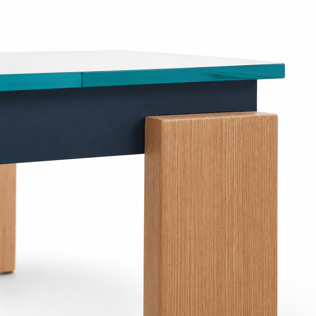 Close-up of a modern table corner showing a white top, teal edge, dark navy apron, and a light natural wood block leg on a white background.