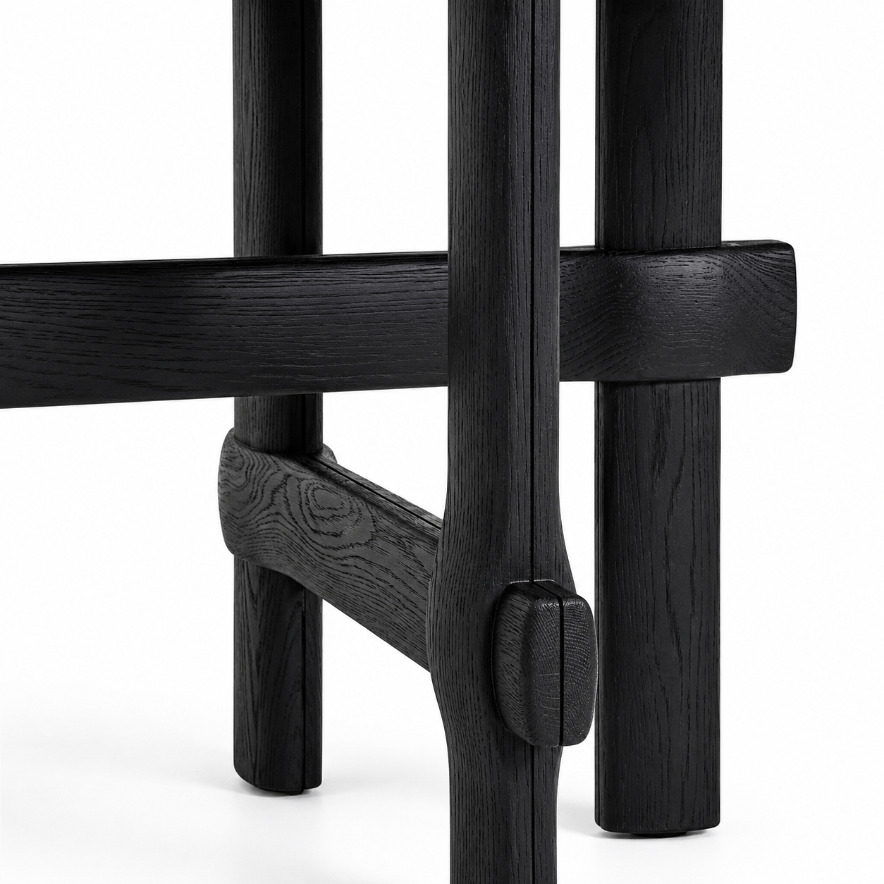 Close-up of a black wooden leg structure with a white background